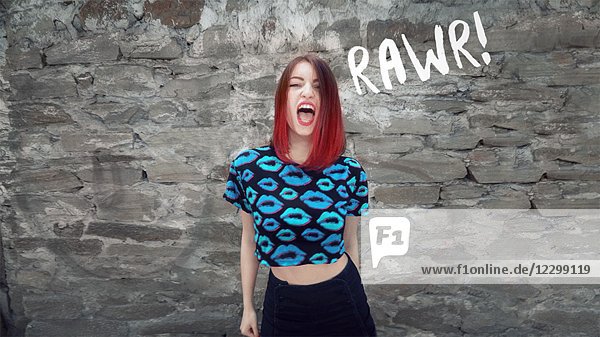 Wütende junge erwachsene Frau in T-Shirt mit blinkenden Lippen  ''RAWR''
