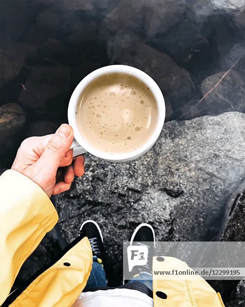 High Angle View of Woman Holding Tasse dampfenden Kaffee durch See