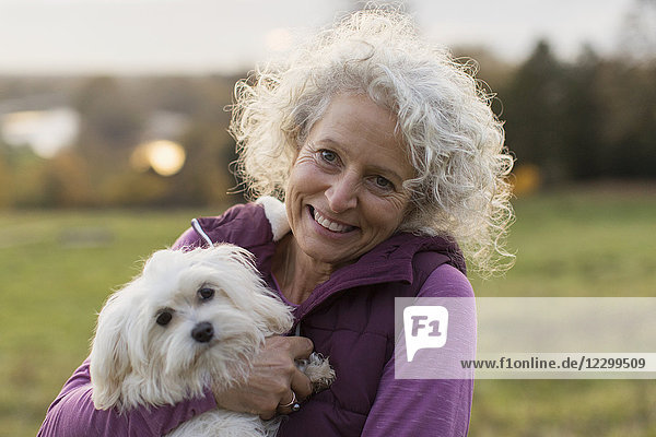 Portrait smiling  happy active senior woman holding dog