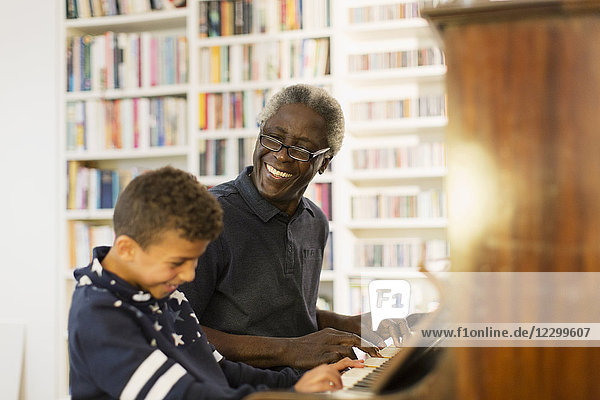Happy grandfather and grandson playing piano