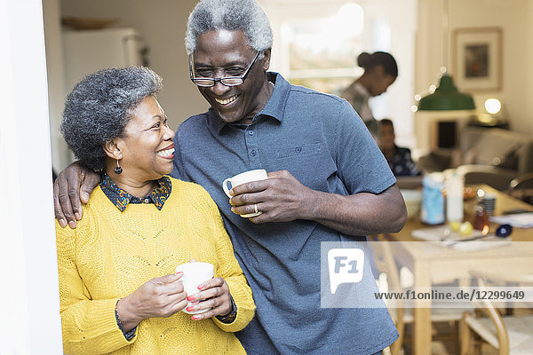 Happy  affectionate senior couple drinking coffee