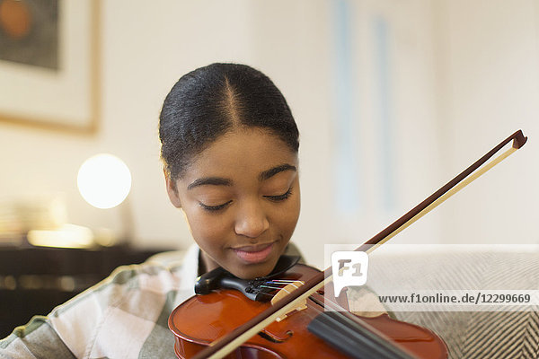 Focused teenage girl playing violin