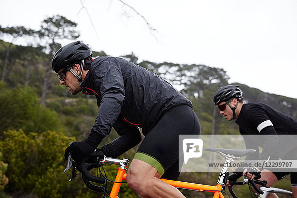 Focused  determined male cyclist cycling uphill