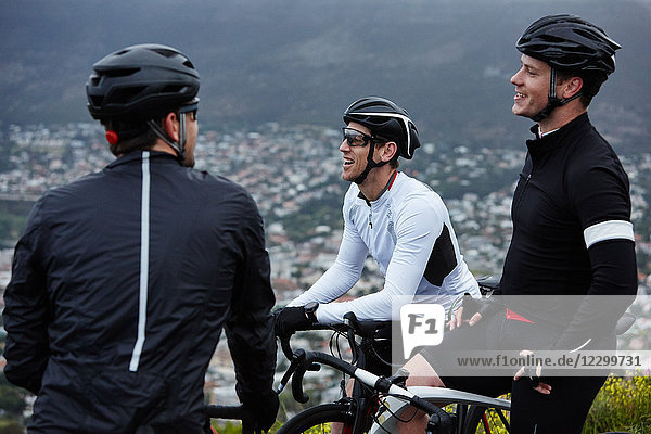 Male cyclist friends taking a break  talking