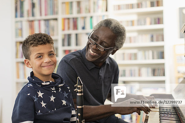 Portrait smiling  confident grandfather and grandson playing piano and clarinet