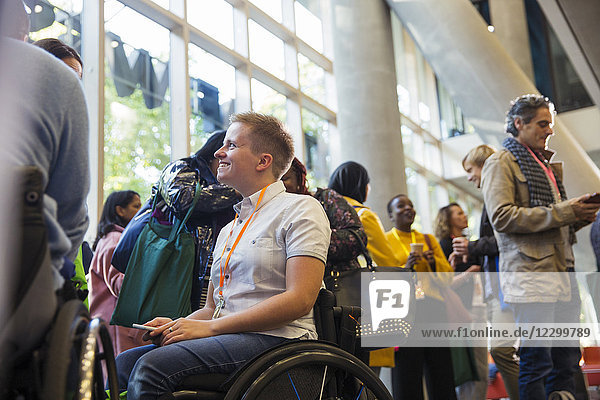Smiling woman in wheelchair at conference