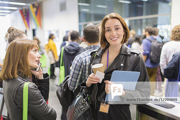 Portrait smiling businesswoman with coffee at conference