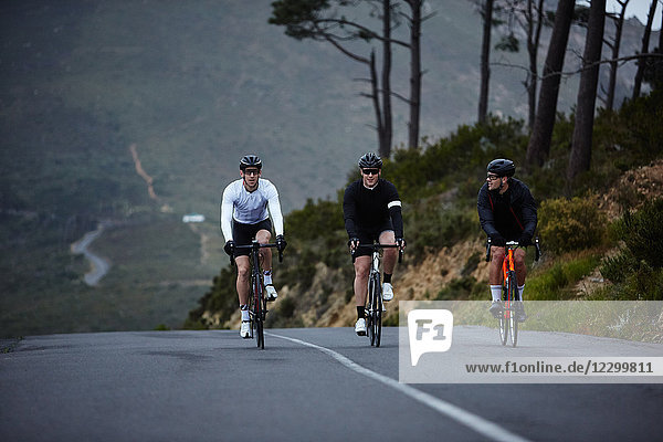 Male cyclists cycling on road