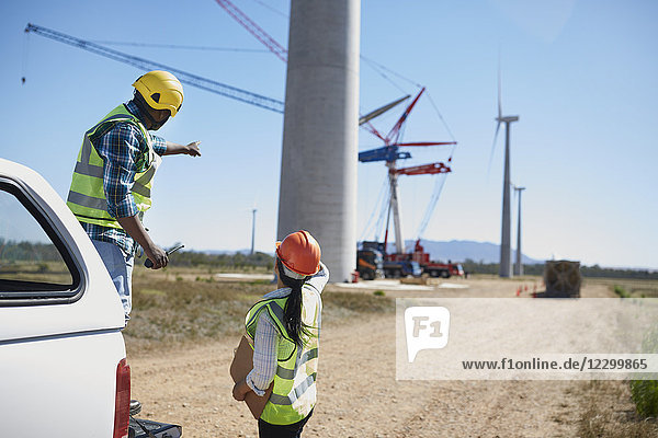Engineers on dirt road at wind turbine power plant