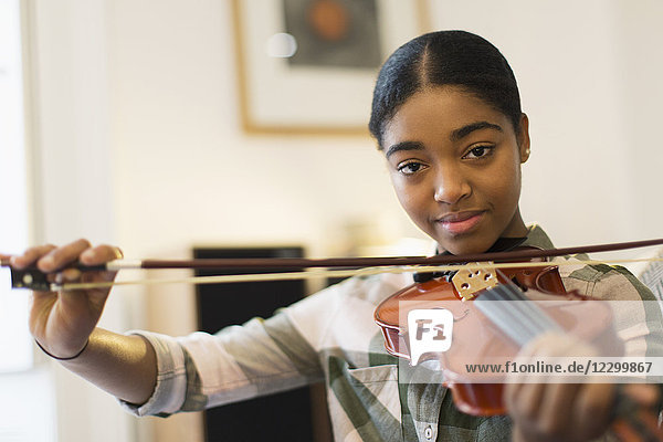 Portrait confident teenage girl playing violin