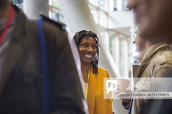 Smiling businesswoman networking  talking to colleague at conference