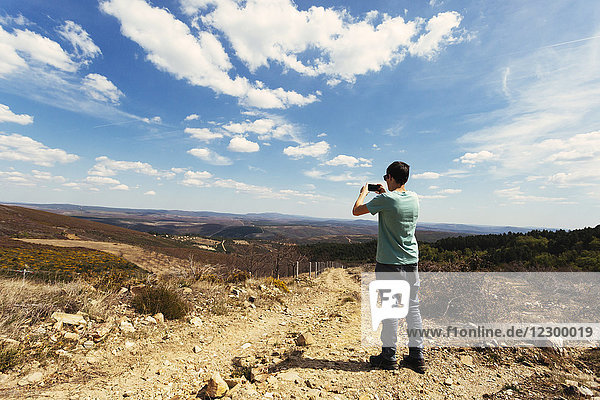 Teenager fotografiert die Landschaft des Montesinho-Naturparks mit seinem Smartphone  Portugal