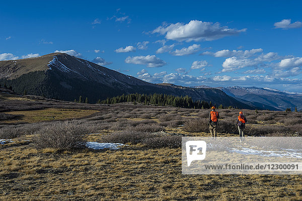 Männlicher und weiblicher Jäger beim gemeinsamen Wandern in den Bergen bei sonnigem Wetter  Colorado  USA