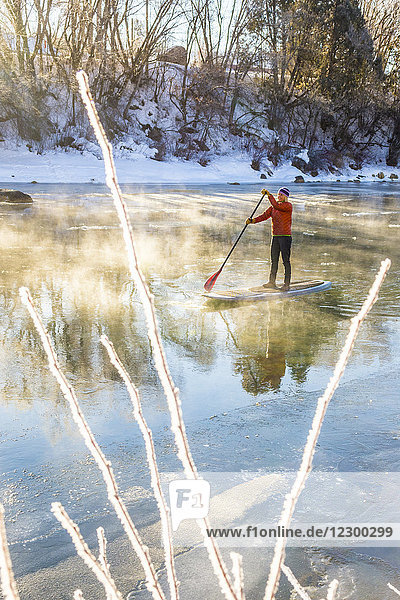 Erwachsene Frau beim Paddeln auf dem vereisten Animas River im Winter  Durango  Colorado  USA