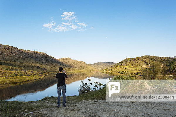Teenager photographing River Douro and surrounding landscape with smart phone Portugal