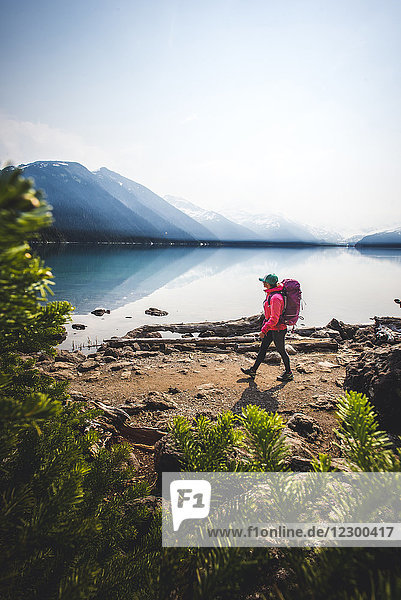 Side view of woman hiking along shore of Lake Garibaldi  British Columbia  Canada