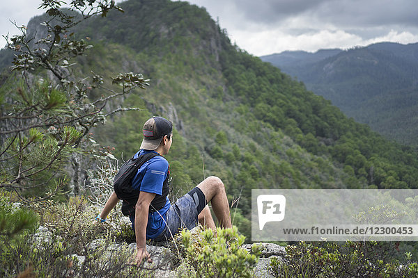 Junger Mann  sitzend  Blick auf die Berge  Hidalgo  Mexiko
