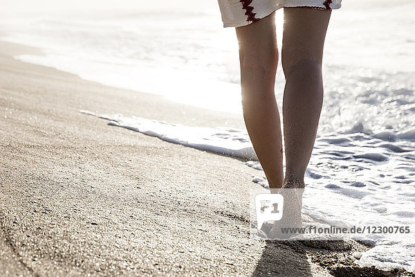 Tiefschnittansicht der Beine einer Frau  die barfuß am Strand läuft  Oahu  Hawaii-Inseln  USA