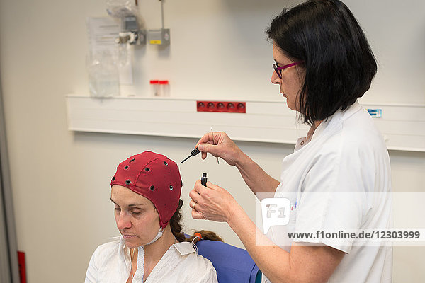 Reportage in der epileptologischen Abteilung des Krankenhauses von Nizza  Frankreich. Langzeit-EEG (3 Tage) für eine Untersuchung auf partielle Epilepsie. Die Krankenschwester benutzt das Headset als Marker. Diese Technik erleichtert die Platzierung der Sensoren erheblich.