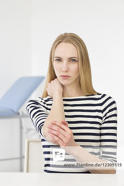 Weibliche Patientin  die wegen Schmerzen im Ellenbogen konsultiert wird.