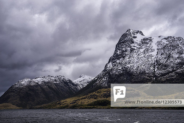 Majestätische Naturkulisse mit Bergen an der Küste unter dramatischem Himmel  Patagonien