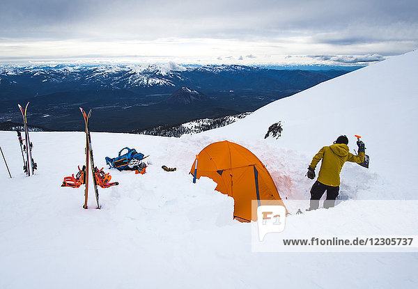 Man camping with tent in winter at Mt Shasta  California  USA