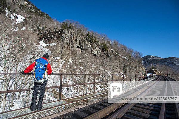 Eiskletterer  der an einem warmen Wintertag zum Eisklettern in die Frankenstein-Felsen steigt  Crawford Notch  New Hampshire  USA