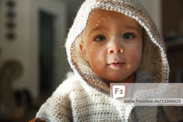 Headshot portrait of baby boy in hooded knit sweater