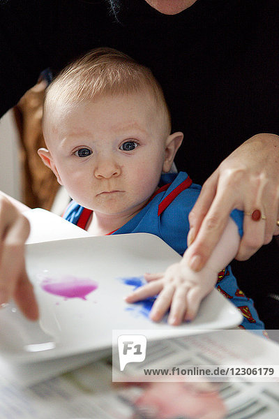 Mutter hilft Baby beim Malen Kunst tropft Farbe auf Papier  Kerroch  Bretagne  Frankreich