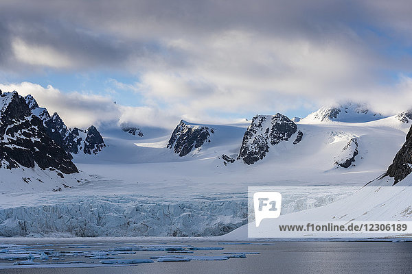 Schöne Naturkulisse eines Gletschers in der Arktis mit schneebedeckten und felsigen Bergen im Hintergrund  Spitzbergen  Svalbard und Jan Mayen  Norwegen