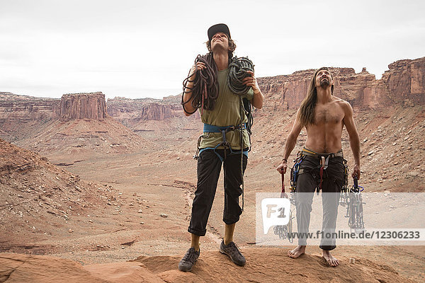 Front view of two rock climbers looking up while preparing to climb in Moab  Utah  USA