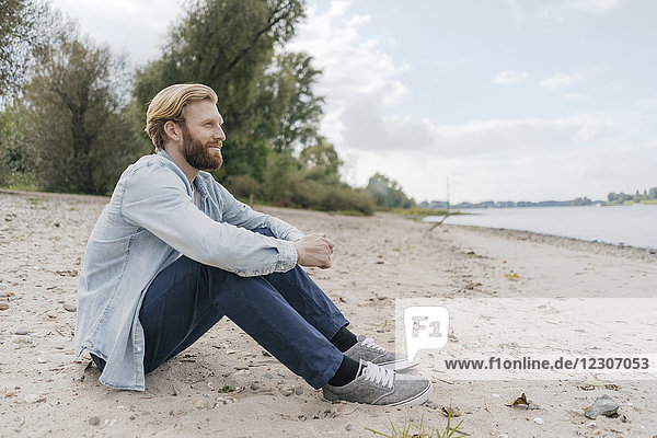 Deutschland  Düsseldorf  entspannter Mann am Strand mit Blick auf den Strand