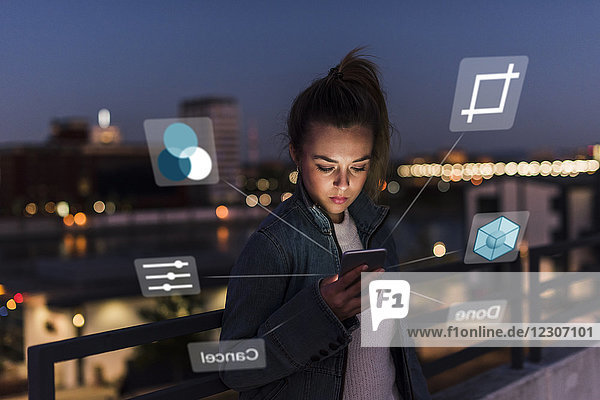 Junge Frau im Freien bei Nacht mit Daten aus dem Smartphone