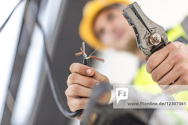 Close-up of electrician working with wire cutter
