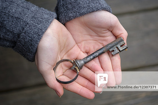 Hands holding an old key  close-up