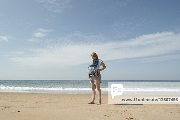 Spanien  Cape Trafalgar  Mutter mit Baby im Tragesitz am Strand