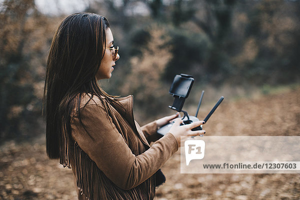 Junge Frau navigiert Drohne mit Fernwirktechnik