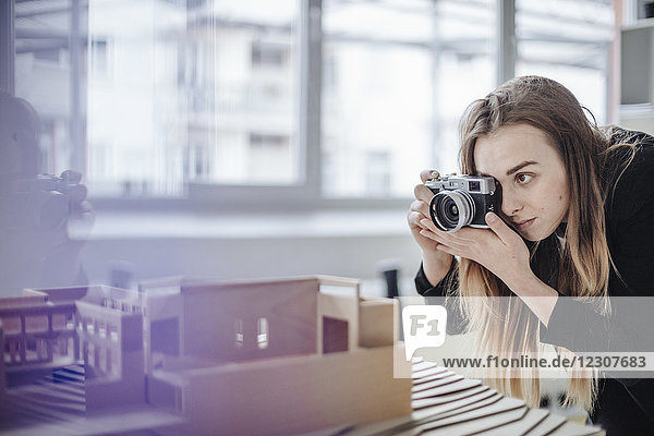 Architect taking photo of architectural model in office