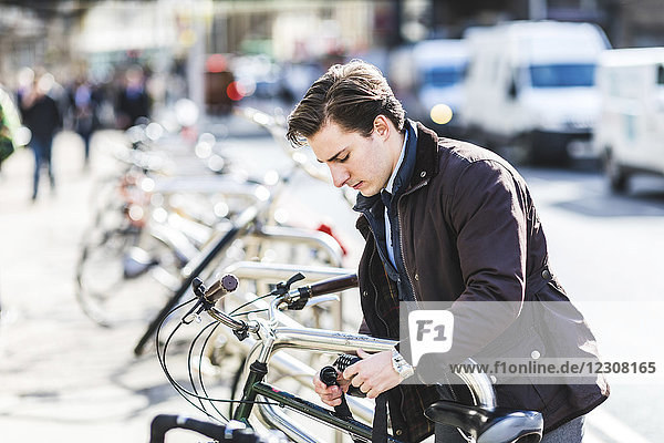 Geschäftsmann sperrt Fahrrad in der Stadt