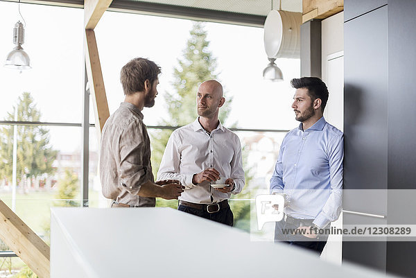 Three businessmen talking during coffee break