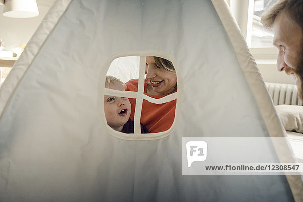 Glückliche Familie beim Spielen im Zelt zu Hause