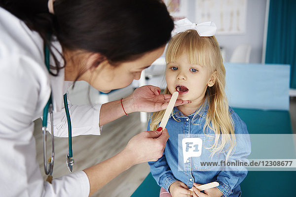 Ärztin untersucht Mädchen in der Arztpraxis