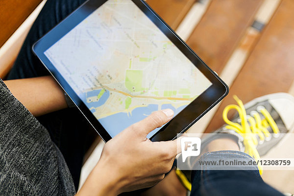 Nahaufnahme einer Frau  die ein Tablett mit digitaler Straßenkarte hält