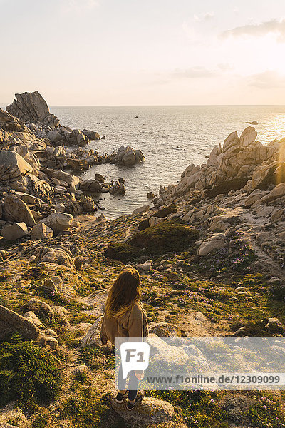 Italien  Sardinien  Frau auf einer Wanderung auf dem Felsen an der Küste stehend