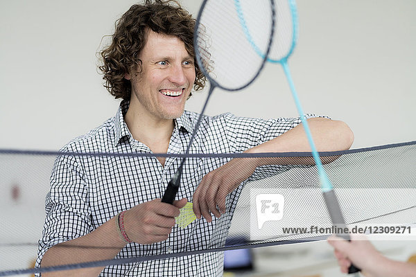 Geschäftsmann gewinnt Badmintonspiel im Büro