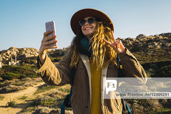 Italien  Sardinien  glückliche Frau auf einer Wanderung mit einem Selfie