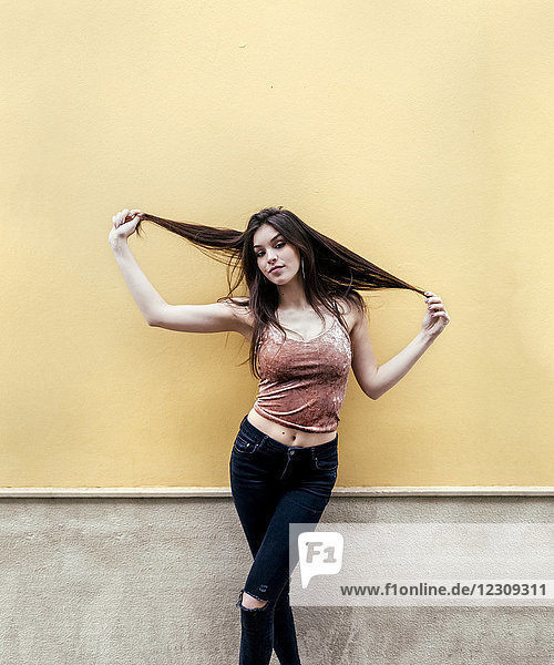 Portrait of a beautiful brunette woman in front of a wall