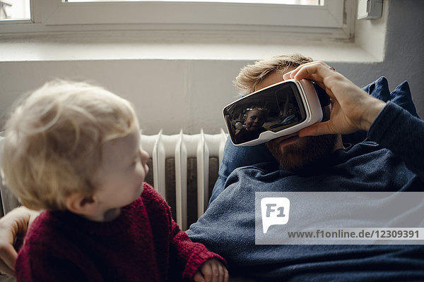 Vater und Sohn spielen zu Hause mit VR-Brille
