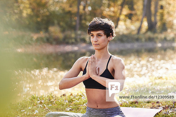 Mittlere erwachsene Frau im Wald praktiziert Yoga  Meditation