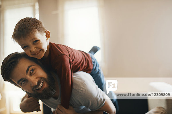 Porträt eines glücklichen Vaters und eines kleinen Sohnes  die zusammen zu Hause spielen.